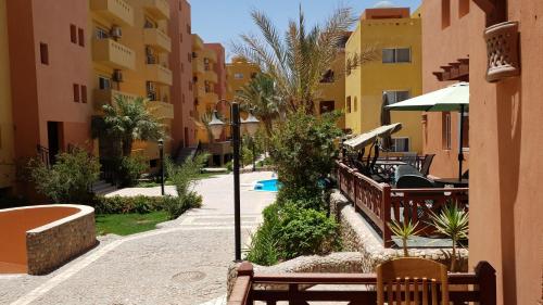 a courtyard with benches and tables and buildings at Al Dora Residence Appartement in Hurghada