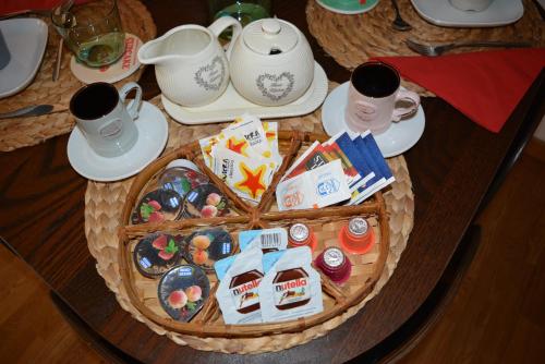 un tavolo con un cesto di cibo e tazze sopra di PantheonDreamSuite a Roma