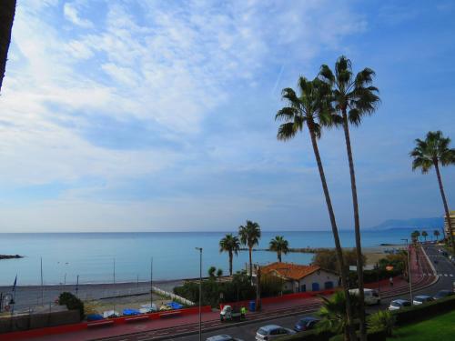 a view of a street with palm trees and the ocean at Casa Lea in Ventimiglia