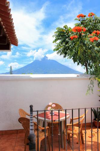 a table and chairs on a balcony with a view of a mountain at Hotel Real Antigua in Antigua Guatemala