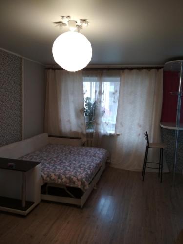 アリメチエフスクにあるApartment on Shevchenkoのベッドルーム1室(ベッド1台、シャンデリア、窓付)