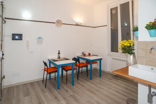 cocina con 2 mesas, sillas y fregadero en shelley affittacamere, en La Spezia