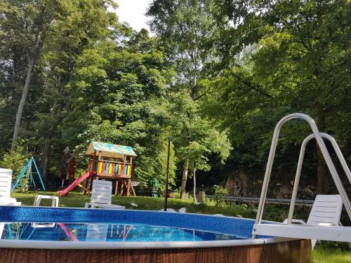a pool in a yard with a playground at Hotel Valdis in Pastra