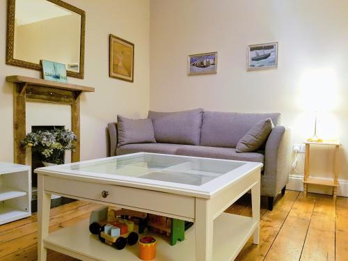 een woonkamer met een bank en een tafel bij Big, Beautiful, Cosy Falmouth House in Falmouth