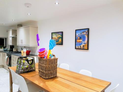 a kitchen with a wooden table with a basket on it at Big, Beautiful, Cosy Falmouth House in Falmouth