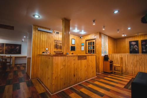 Habitación grande con paredes y suelo de madera. en Hotel Hallef, en Puerto Natales