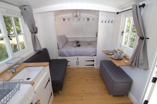 Habitación pequeña con cama y mesa. en Riverside Bothy at Allt A'Mhuilinn en Spean Bridge