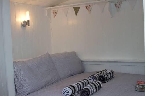 a gray couch with four black and white pillows on it at Riverside Bothy at Allt A'Mhuilinn in Spean Bridge