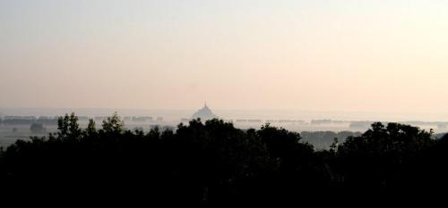 a foggy view of a building in the distance with trees at Rêve du Revert in Roz-sur-Couesnon