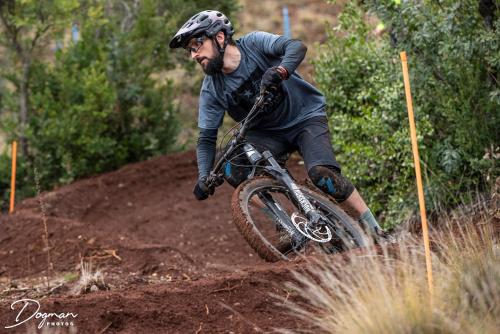 un hombre montando una bicicleta en un camino de tierra en Lodge Colbún, en Colbún Alto