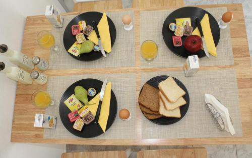 three black plates of food on a wooden table at Litsa's Suite in Heraklio Town