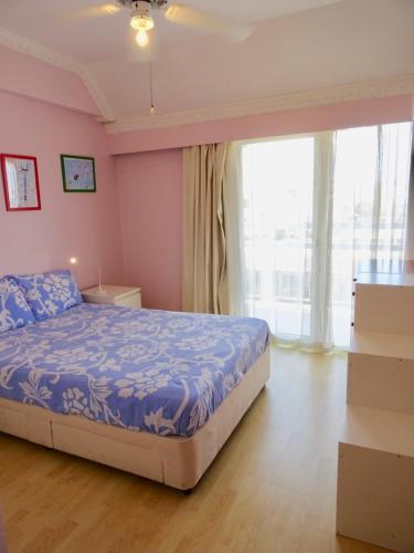 a bedroom with a bed and a large window at Camilla City apartment in Larnaca