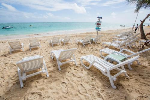 a group of chairs and tables on a beach at Hotel Checkin El Cortecito Beach in Punta Cana