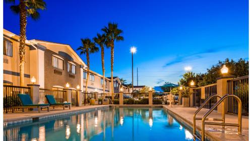 - une piscine avec 2 chaises et des palmiers dans l'établissement Best Western Mayport Inn and Suites, à Atlantic Beach