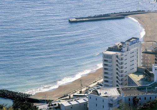 a view of a beach with a barge in the water at Atagawa Yamatokan in Higashiizu