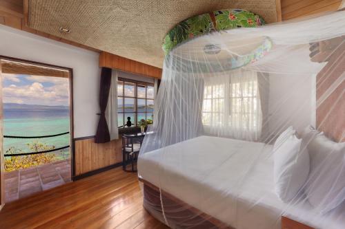 a bedroom with a bed with a view of the ocean at NoaNoa Private Island in Taytay