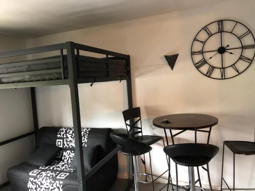 ル・デヴォリュイにあるStation de ski Superdevoluy du bois d aurouzeの二段ベッド、テーブル、時計が備わる客室です。