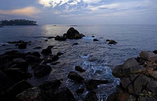 a group of rocks on the shore of the ocean at Turtle Reef Guest in Mirissa