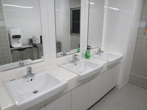 ein Badezimmer mit zwei Waschbecken und zwei Spiegeln in der Unterkunft Hotel Mirai in Yokohama