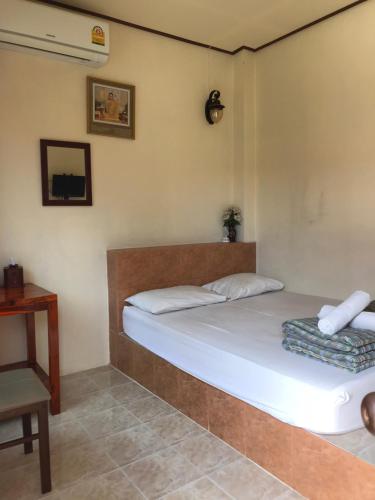 a bedroom with a bed and a chair and a table at Baan Aomsin in Chiang Khan