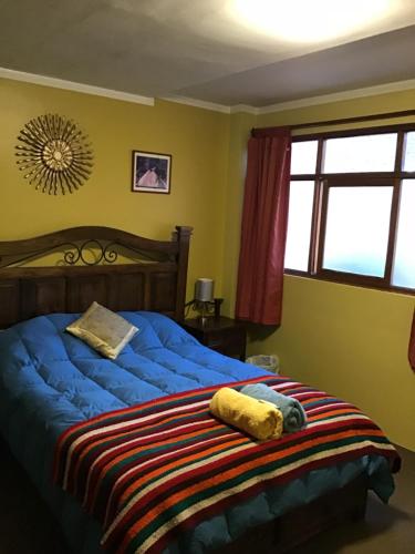 a bedroom with a bed with a blue comforter at La Casa de Zarela in Huaraz