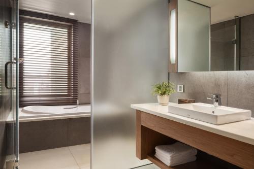 a bathroom with a sink and a shower at Hotel Emion Phnom Penh in Phnom Penh