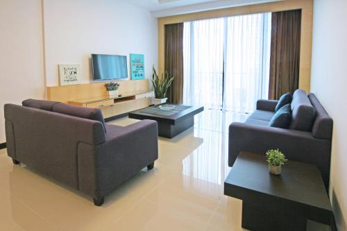 a living room with two couches and a television at Bernard Holiday Home @ Imperial Suites Kuching in Kuching