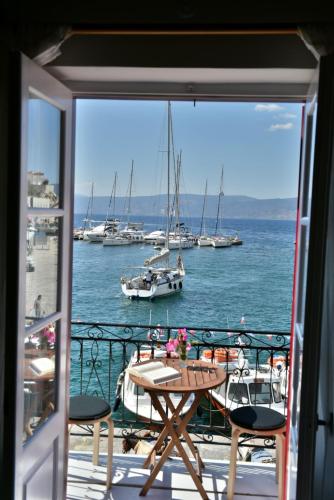a balcony with a table and boats in the water at Hydra Port Apartments-Serenity in Hydra
