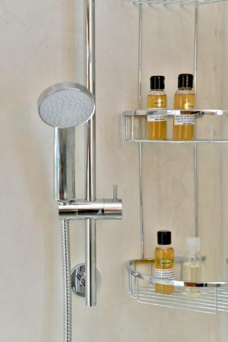 a bathroom with three shelves with bottles of honey at Hydra Port Apartments-Serenity in Hydra