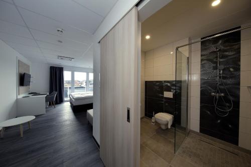 AlpenにあるHotel an der Burgschänkeのシャワー付きのホテルルームとベッドルーム1室が備わります。