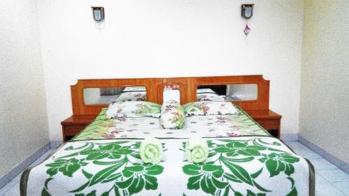 a bedroom with a bed with flowers on it at Melissa Palace Hotel and Karaoke in Parapat
