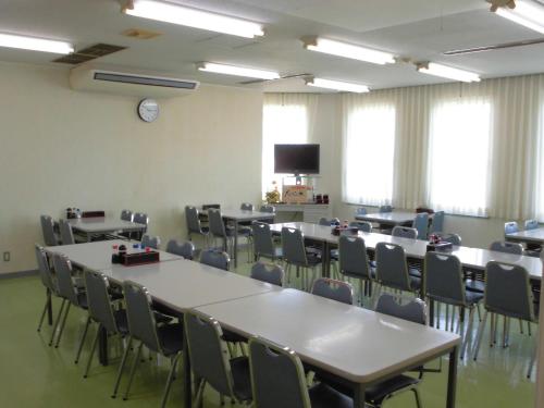 a conference room with tables and chairs and a tv at Oyabe City Cycling Terminal in Oyabe