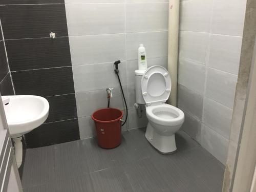 uma casa de banho com um WC, um lavatório e um balde em Taman Rambai Homestay em Malaca