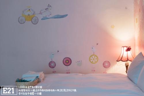 a bedroom with a white bed with decorations on the wall at Fengjia Love I Hostel in Taichung