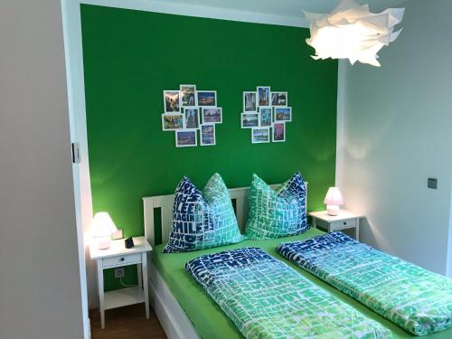 a bedroom with a green wall and a bed with pillows at Louisenstraße 31 in Dresden