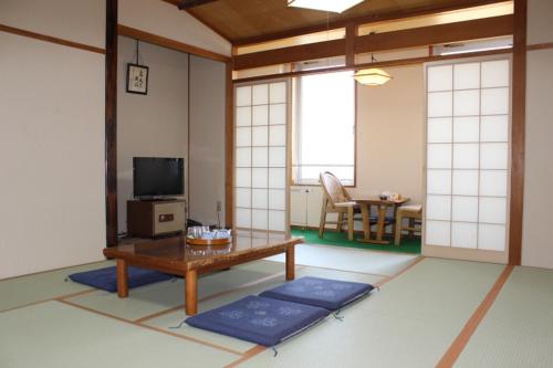 a living room with a table and a tv at Oyabe City Cycling Terminal in Oyabe