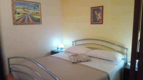 a bed with a stuffed animal sitting on top of it at Antico Palazzo in Giardini Naxos