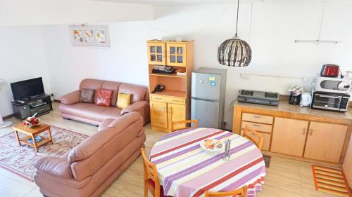 a living room with a table and a kitchen at Palmyre Residence 7 & 8 LICENSED BY TOURISM AUTHORITY 10071 in Flic-en-Flac