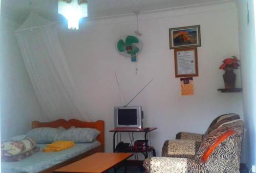 a living room with a couch and a computer on a table at Tourist Nest Hotel in Kampala