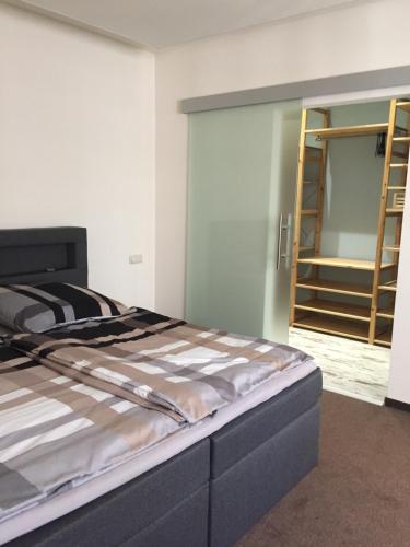 1 dormitorio con 1 cama y puerta con escalera en Ferienwohnung „Blaues Schild“, en Dorndorf