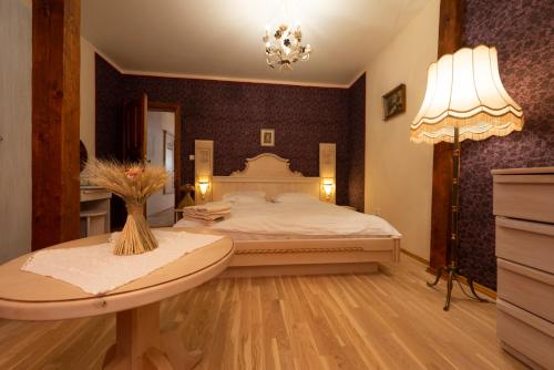 a bedroom with a large bed and a table at Hotel Barcadam in Banská Štiavnica