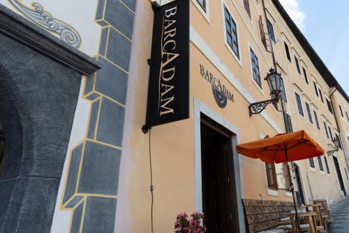 a sign on the side of a building with an orange umbrella at Hotel Barcadam in Banská Štiavnica