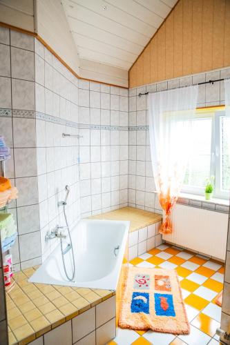 a bathroom with a tub and a window at Das blaue Haus in Daufenbach