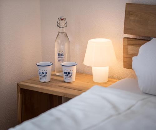 a bottle of water and two cups on a table at Berggasthaus Piz Calmot in Andermatt