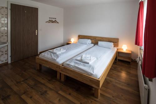 a bedroom with a large bed with white sheets and two lamps at Berggasthaus Piz Calmot in Andermatt