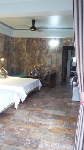 a bedroom with a bed and a stone wall at Limestone View Homestay in Ninh Binh