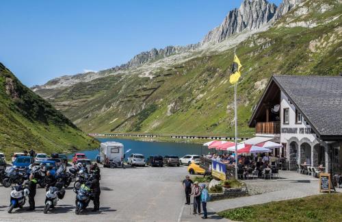 a group of motorcycles parked on a road next to a mountain at Berggasthaus Piz Calmot in Andermatt