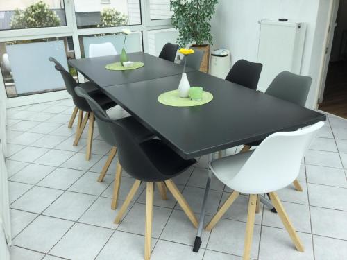 una mesa de comedor negra con sillas blancas en Ferienhaus Weins, en Lieg