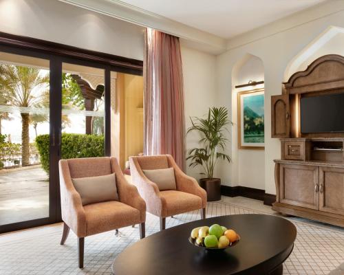 a living room with a table and chairs and a television at Shangri-La Qaryat Al Beri, Abu Dhabi in Abu Dhabi