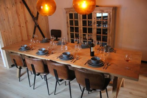 a large wooden table with chairs and wine glasses at Landhuis Züschen in Winterberg